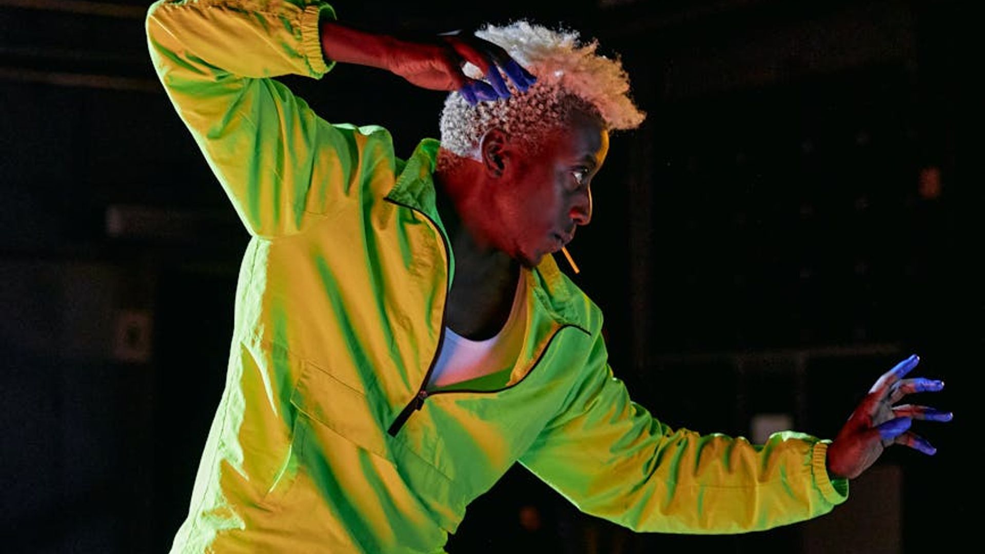 Person doing dynamic movement in a dark studio with neon light
